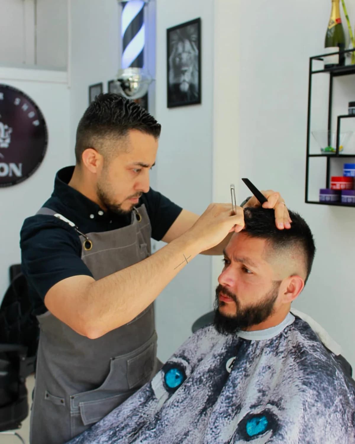 Andrés cortando el pelo a un cliente en Barber Shop Lion