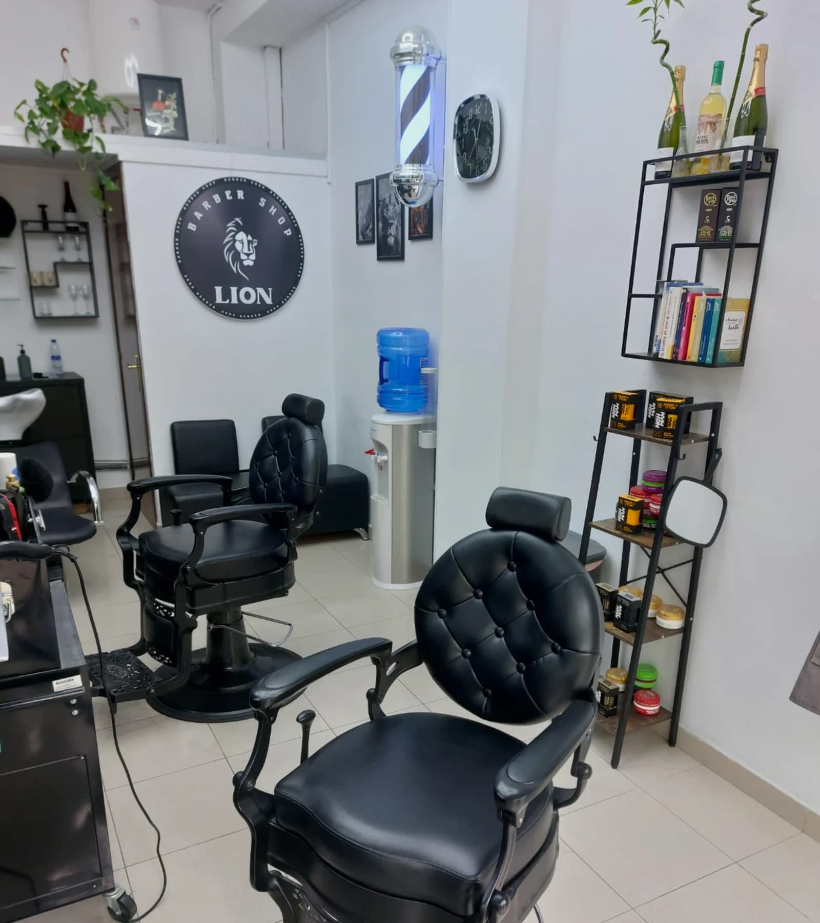 Interior de Barber Shop Lion: paredes de mármol negro, techo con LEDs hexagonales y silla de barbero clásica